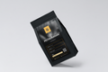 Black coffee packaging with 'SITIO PIGTAURANAN' branding on a light gray background